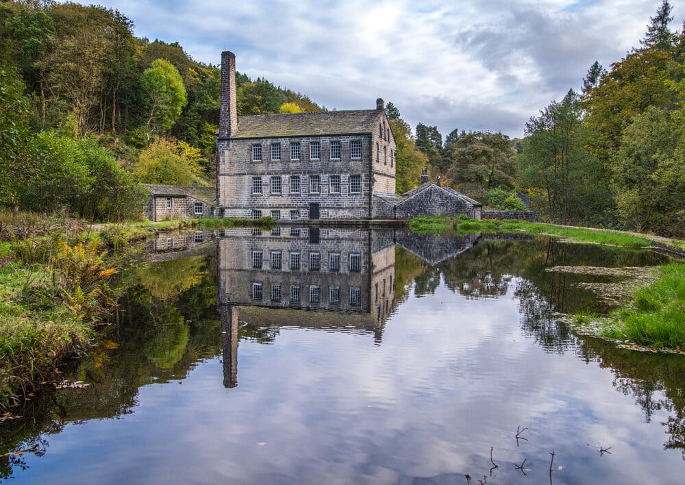 Gibson Mill at Hardcastle Crags surrounded by woodland and waterfalls